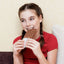 A girl wearing a red t-shirt eating a piece of chocolate